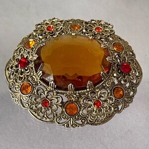 Vintage West Germany brooch featuring a large amber topaz glass filigree gold